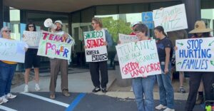 Image of TCSD and labor union members in LSAN in front of Elevate Commercial's reported corporate office with colorful signs telling Elevate to stop rent hikes. Other slogans include "Elevate Deez Nuts", "Stop Hurting Families" and "San Diego Stands with Riviera Estates." 